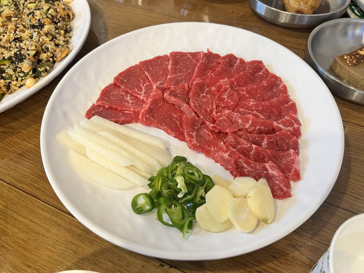 독도네 육사시미 1/2 접시 — 얇게 썬 소고기를 부채꼴로 펴고 배와 고추, 편마늘을 곁들였다 (2026년 9월 12일 직접 촬영)