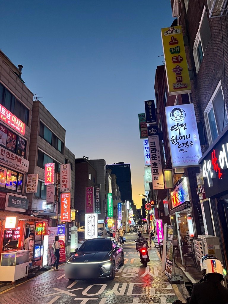 건대 맛의거리의 간판들 — 떡전할머니맥주 1982, 크라운호프, 인도카레, 베트남 마사지 (2026년 9월 초 직접 촬영, 차량 번호판은 가렸다)