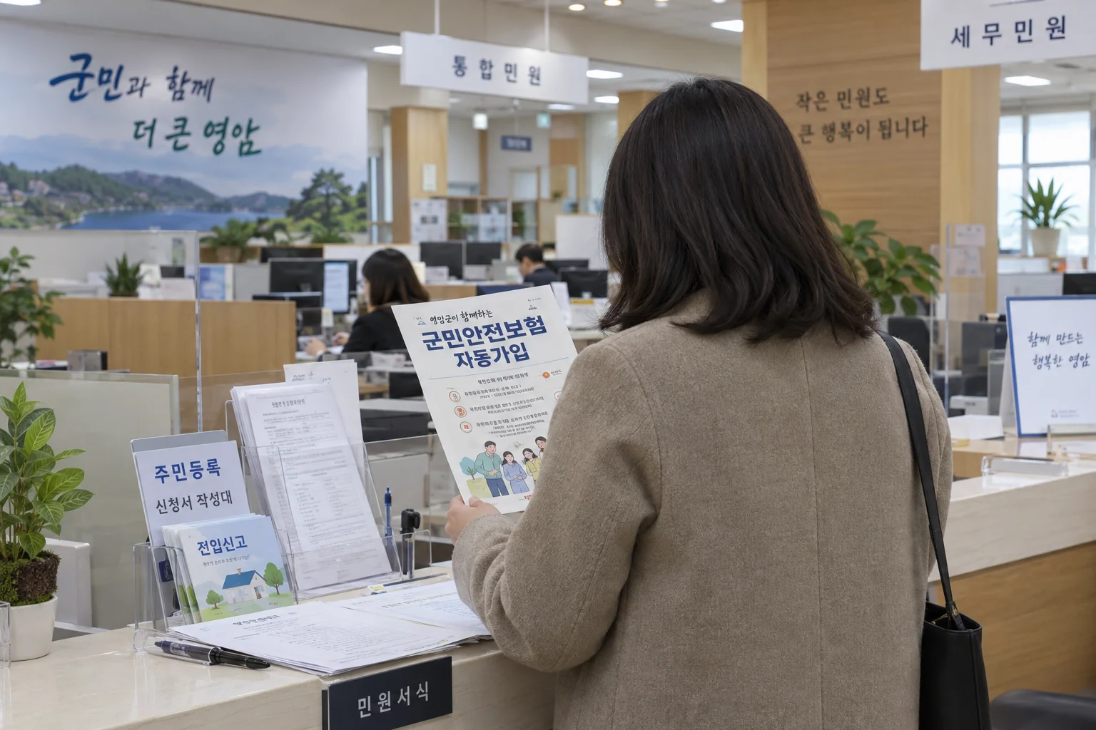 영암군 주민센터에서 자동가입 안내를 확인하는 주민의 뒷모습