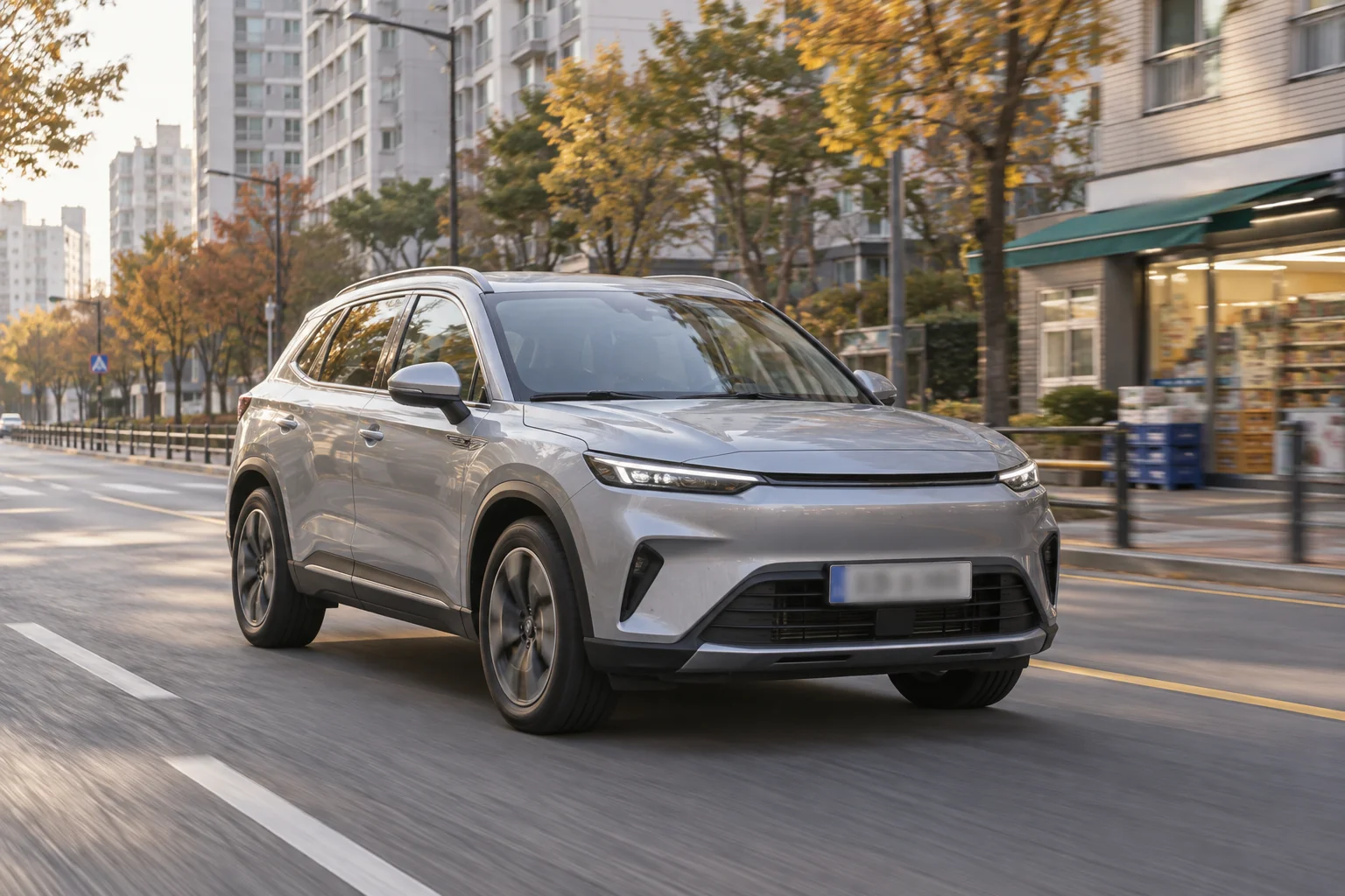 도심 도로를 달리는 은색 컴팩트 하이브리드 SUV